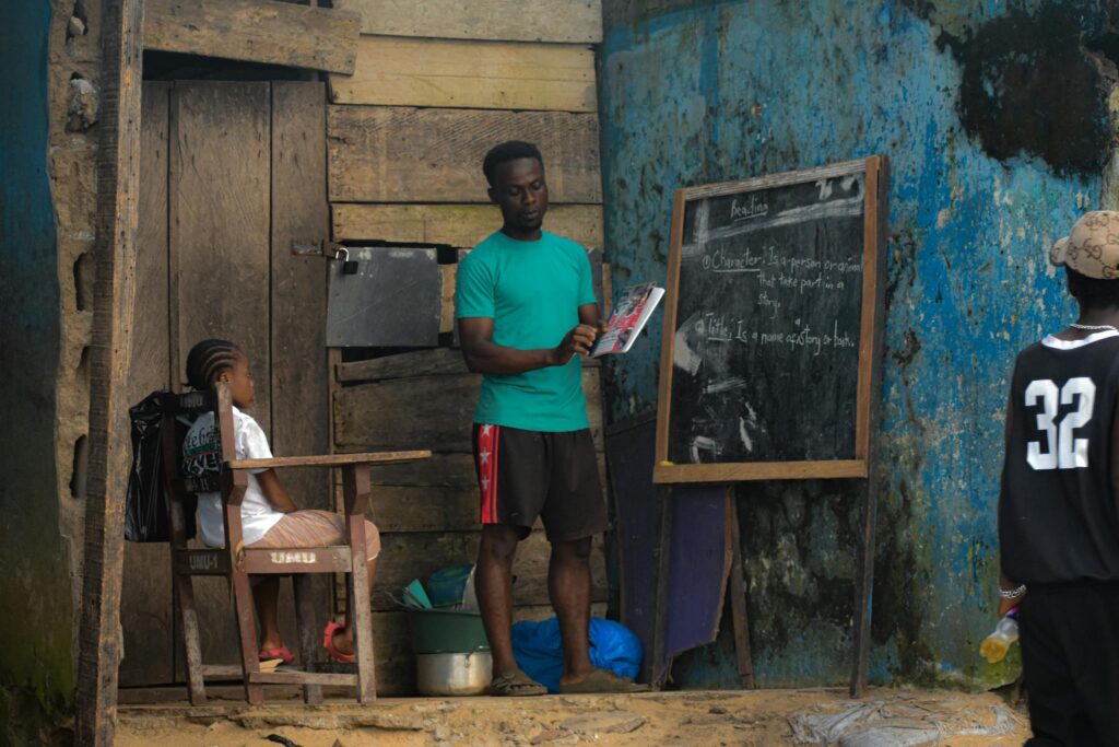 A teacher conducts an outdoor class for children in Monrovia, showcasing community education.